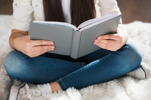 Close-up young girl reading a book